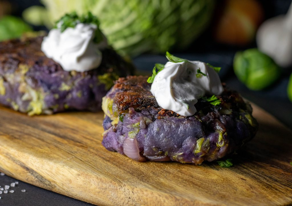 Bubble and Squeak als kleinere Gemüse-Kartoffeltaler. Hier aus lila Kartoffeln gemacht.