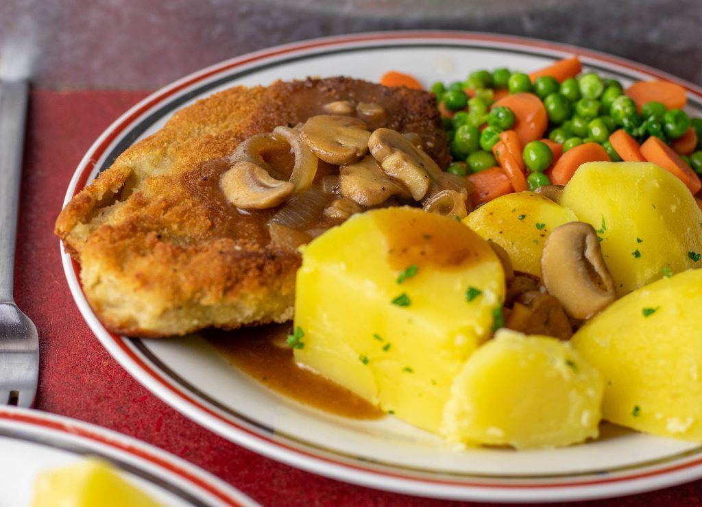 Veganes Schnitzel mit Kartoffeln, Sauce, Erbsen und Möhrchen