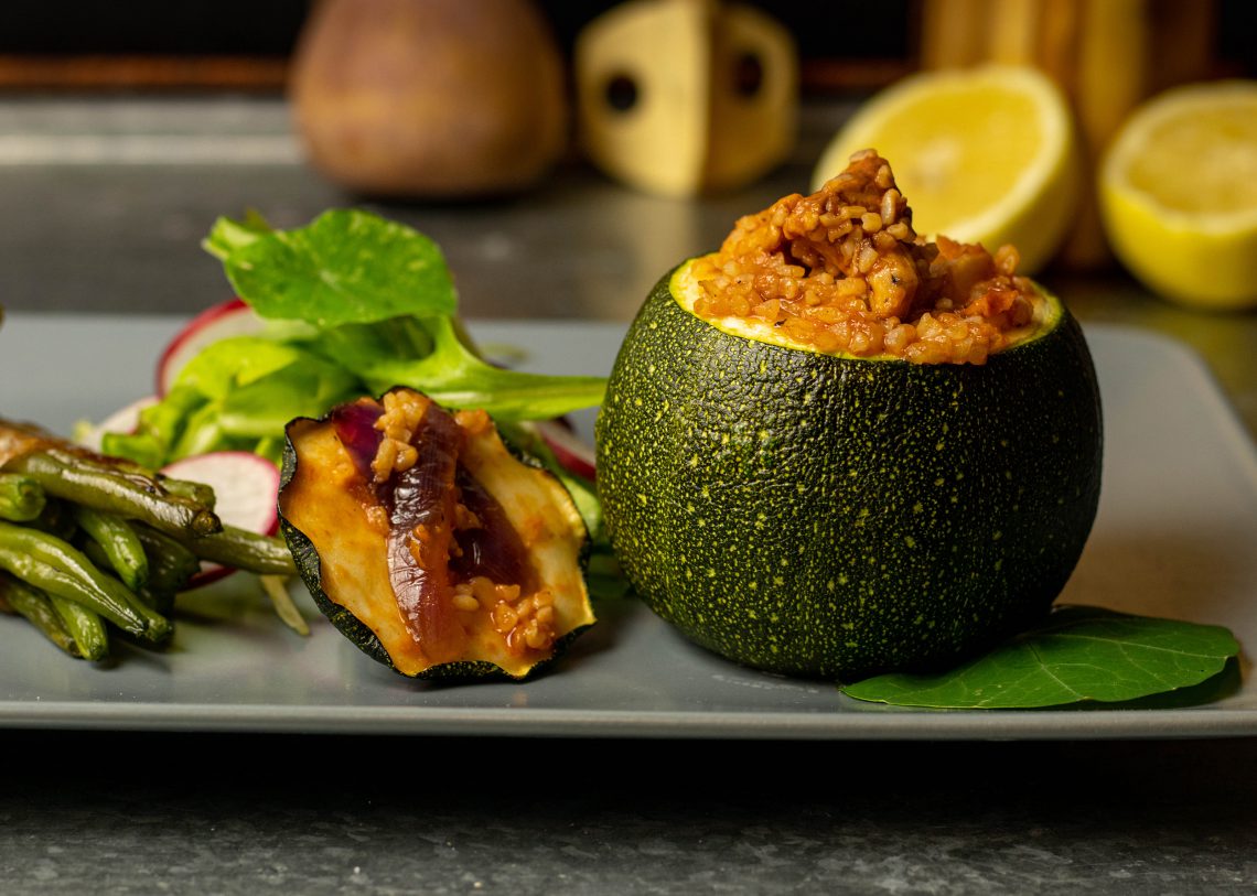 Gefüllte runde Zucchini mit grünen Bohnen im Speckmantel - vegan