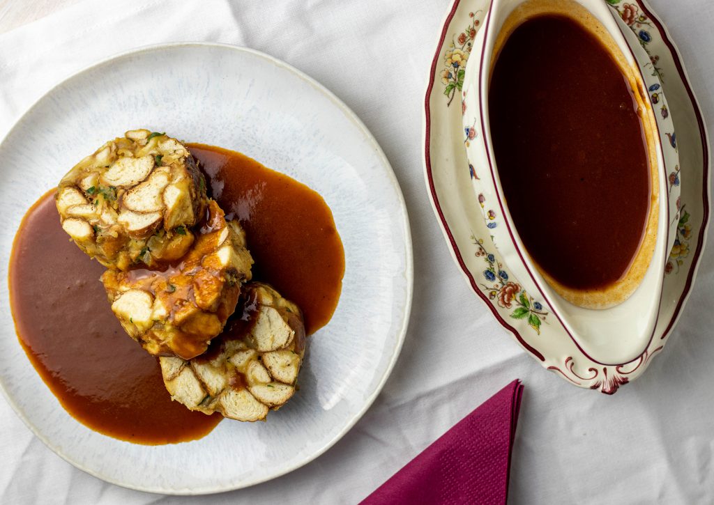 Vegane Bratensauce kann sehr gut vorbereitet werden. Hier köstlich über Laugenknödeln