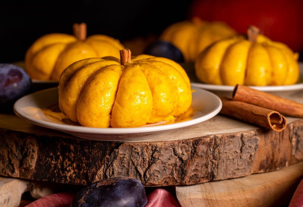 Süße Kürbisbrötchen in lustiger Kürbisform mit einer herbstlich goldenen Farbe