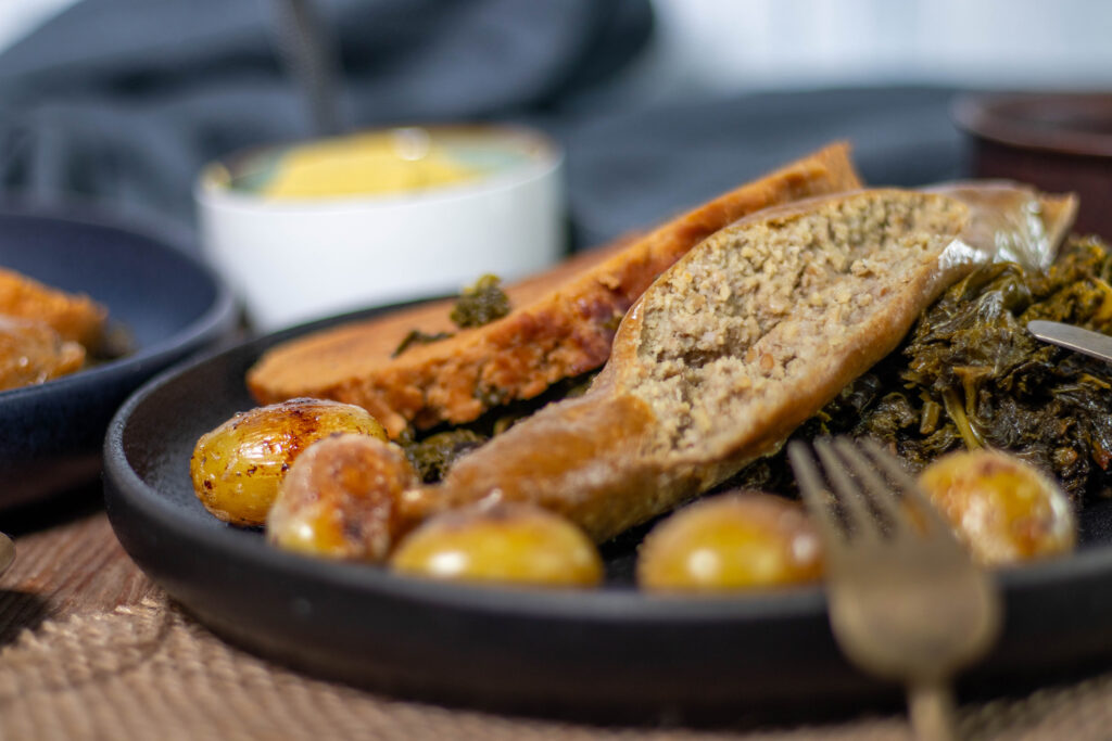 Vegane Pinkel, rauchig-deftig, selbstgemacht, aufgeschnitten auf Grünkohl.