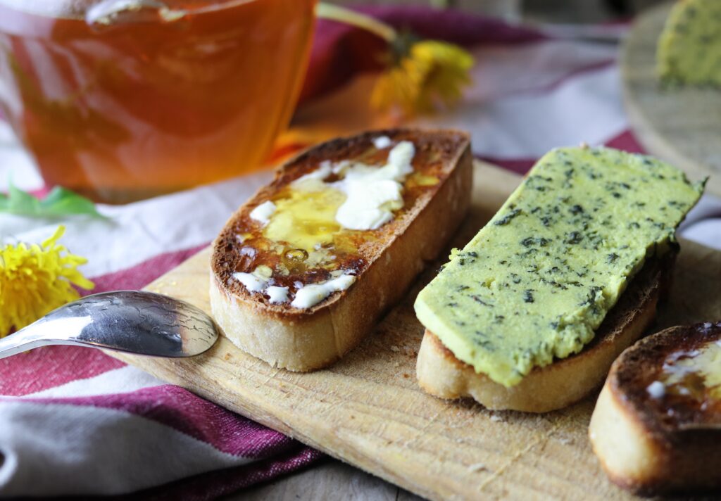 Dandelion honey with vegan butter on bread. Next to it is a bread with my homemade stinging nettle cheese.