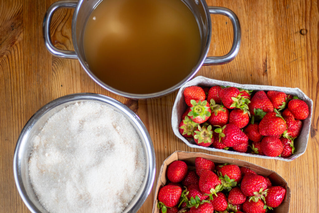 4. Die Zutaten für die Marmelade: Erdbeeren, Gelierzucker und der zuvor angesetzte Apfel-Zitronen-Holunderblüten-Sud.