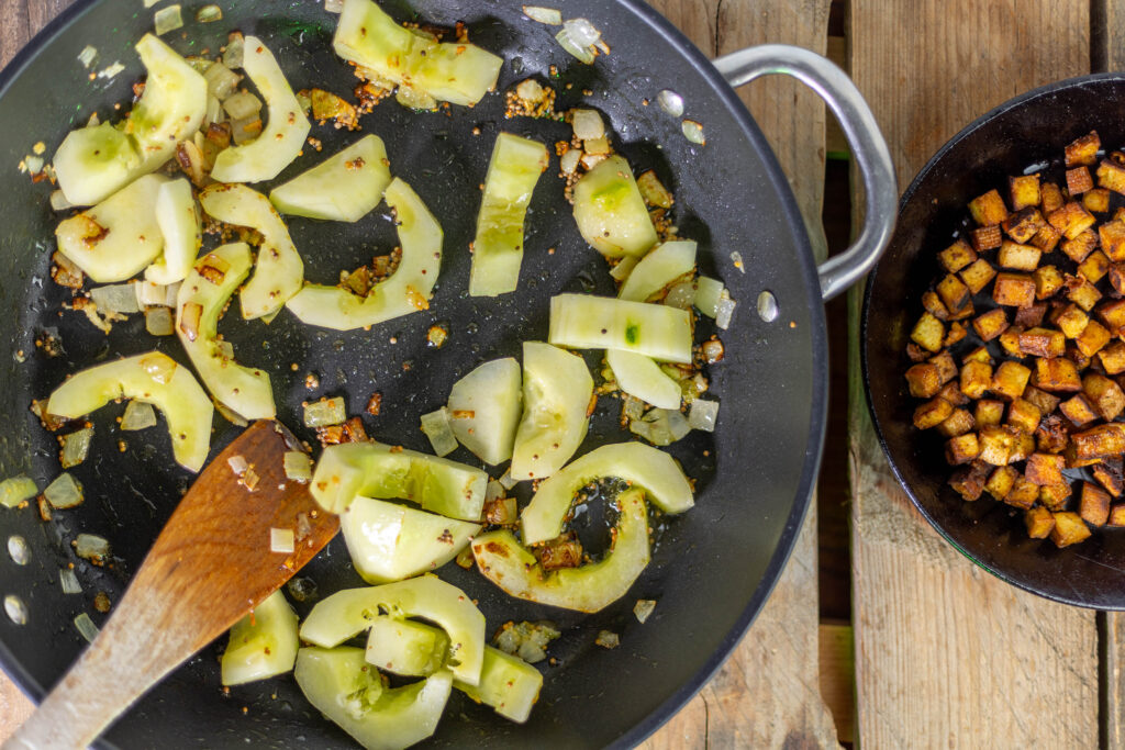 8. Knoblauch und Gurkenstücke dazu geben.