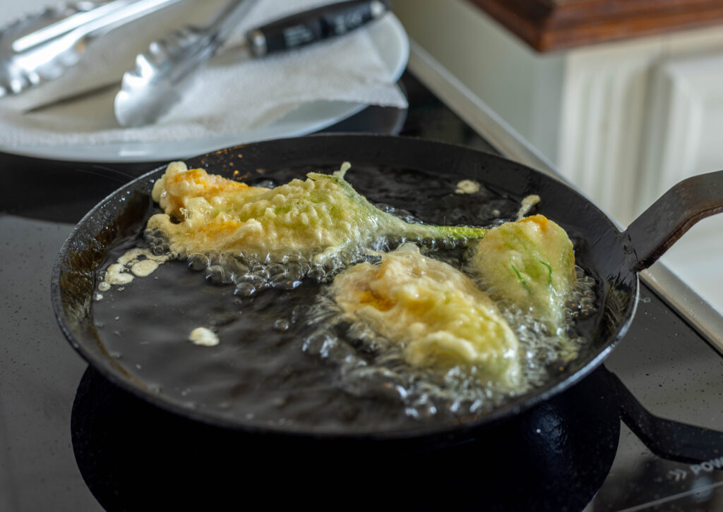 5. Die Zucchiniblüten werden in heißem Öl ausgebacken.