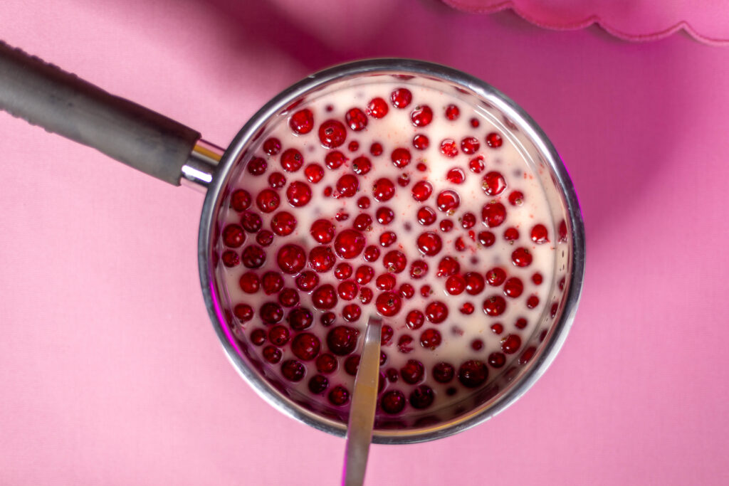 2. Das Puddingpulver mit Zucker und Vanillezucker verrühren. Dann auch die Beeren hinein geben und das Johannisbeerkompott aufkochen.