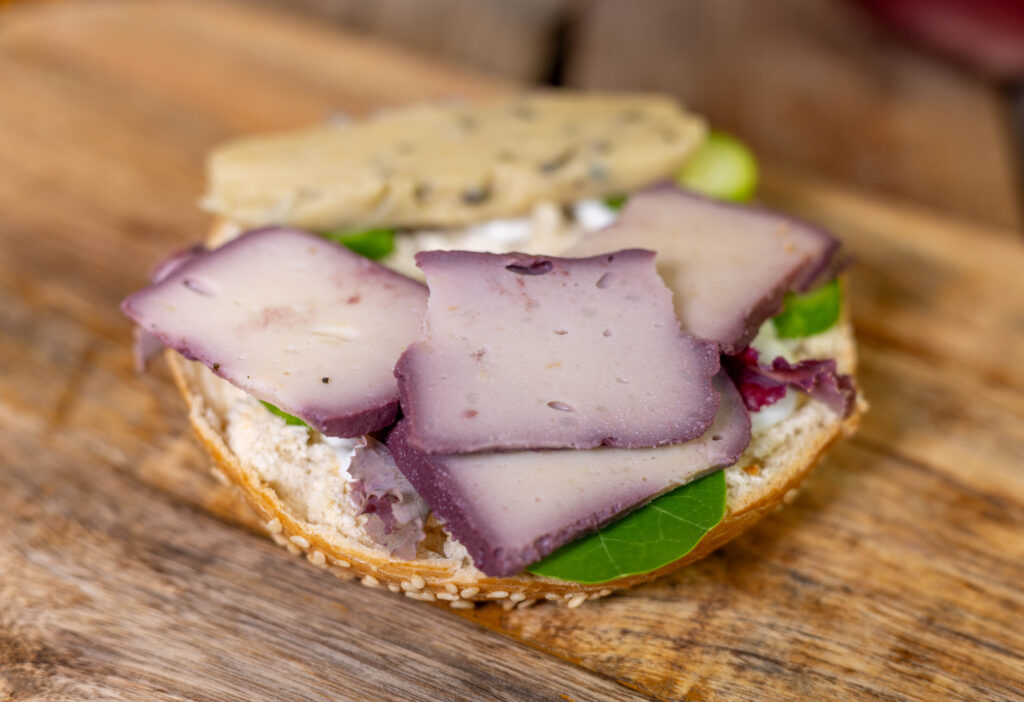 In Rotwein gereifter und frischer Kartoffelkäse mit Kräutern auf einem Bagel vereint.