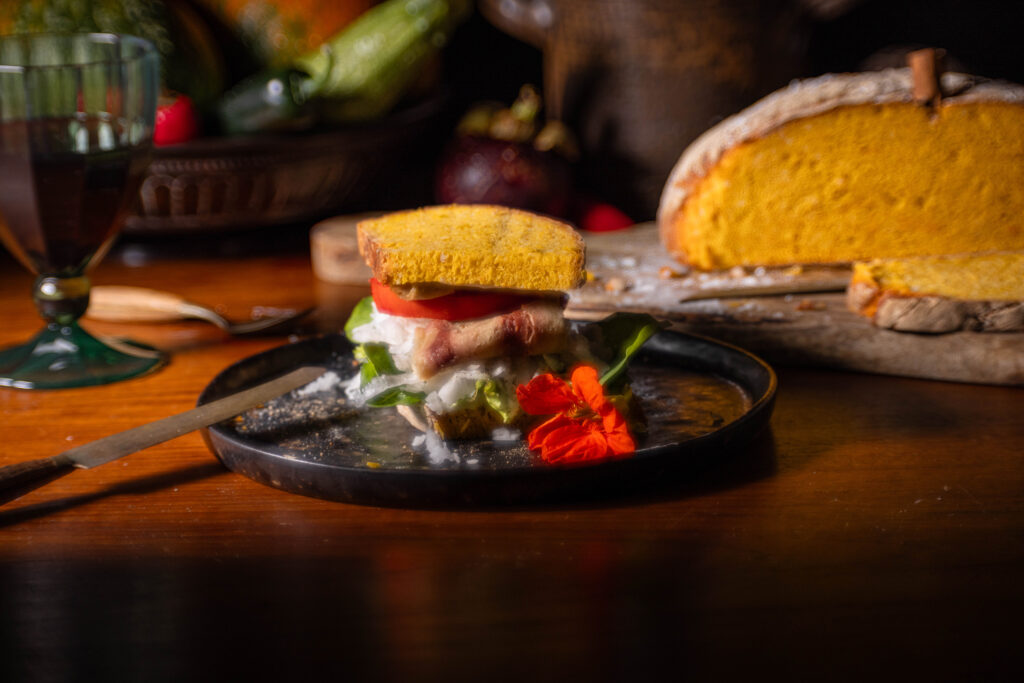 Kürbisbrot belegt mit selbstgemachtem, veganen Schinken, Tomate und Salat aus dem Garten, sowie gehobeltem Rettich.