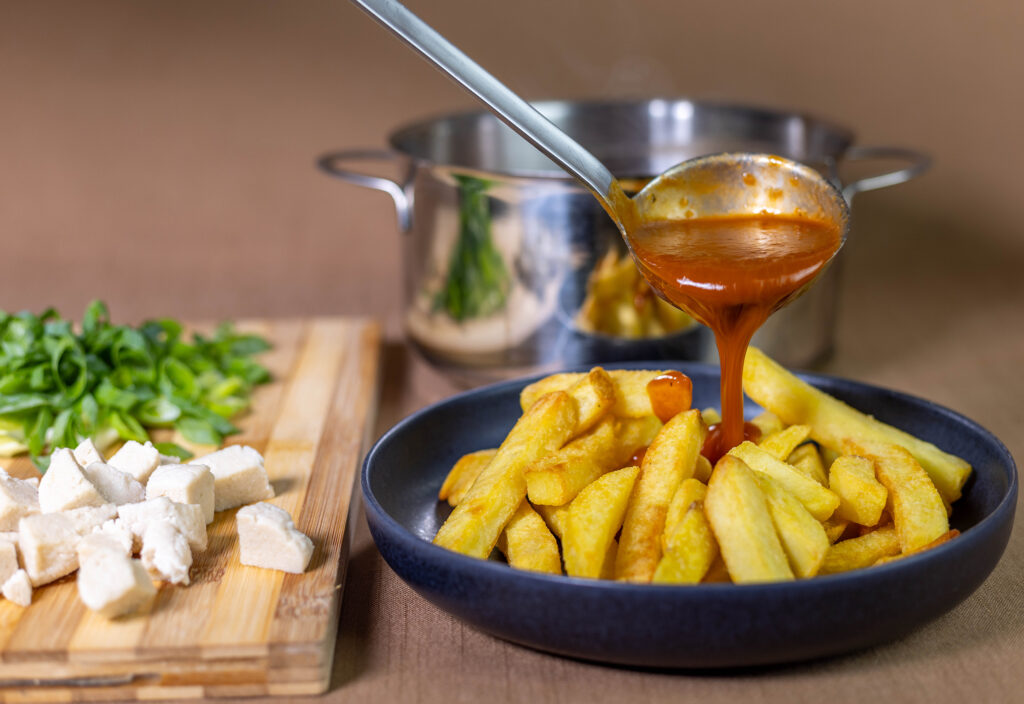 3. Die frisch frittierten, dicken Pommes werden mit der heißen Bratensauce übergossen.