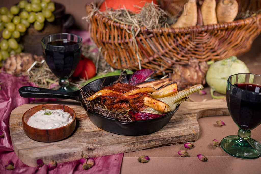 Veganer Heubraten auf Heu und Ofengemüse, mit Salzzitronenschnitzen. Als Dip dazu gibt es veganen Kräuterquark.