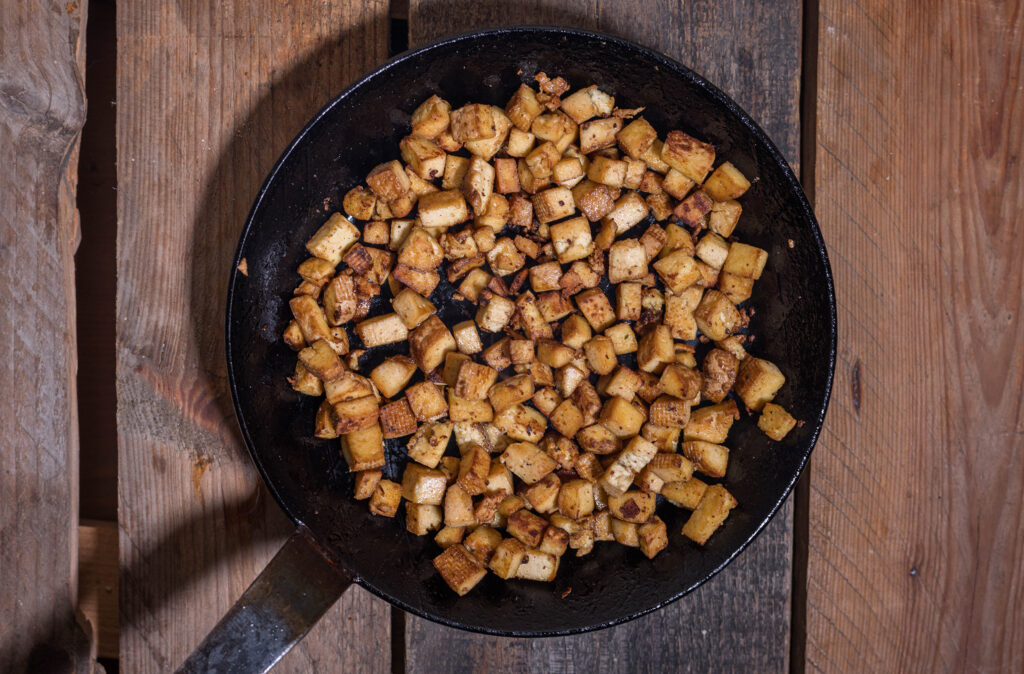 3. Der vegane Speck wird angebraten. Dafür wird der Räuchertofu mit Sojasauce abgelöscht und kross gebraten.