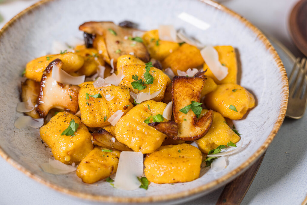 Selbstgemachte Kürbis-Gnocchi mit gebratenen Steinpilzen in veganer Salbeibutter