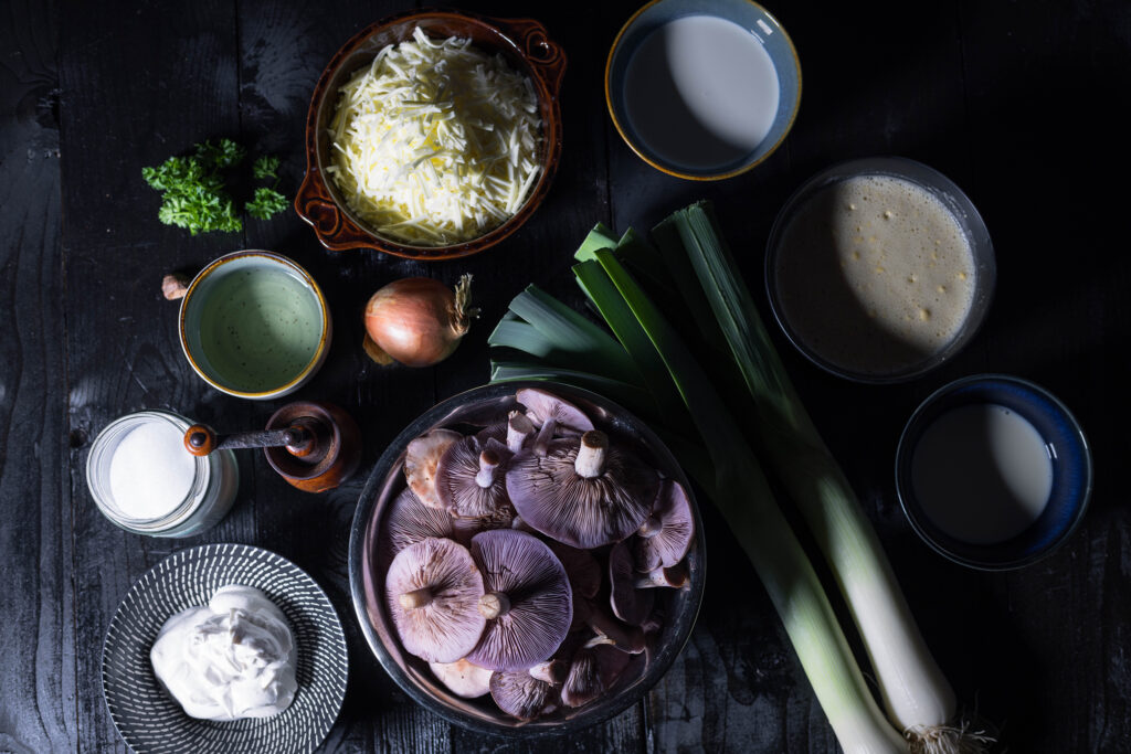 1. Alle Zutaten für die Lauch-Pilz-Quiche mit violetten Rötelritterlingen.