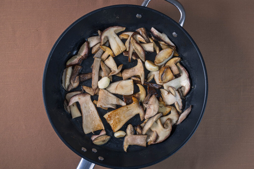 3. Die Pilze werden mit den ganzen Knoblauchzehen gebraten.