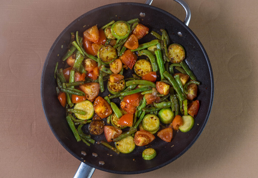 8. Dann auch die Tomaten dazu geben und weiter braten.