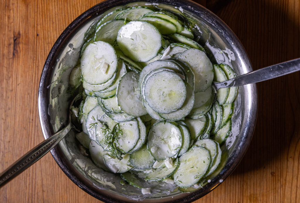 3. Die Gurkenscheiben mit den Zwiebelwürfeln und dem Dressing verrühren. Den Gurkensalat anschließend mindestens 10 Minuten ziehen lassen.