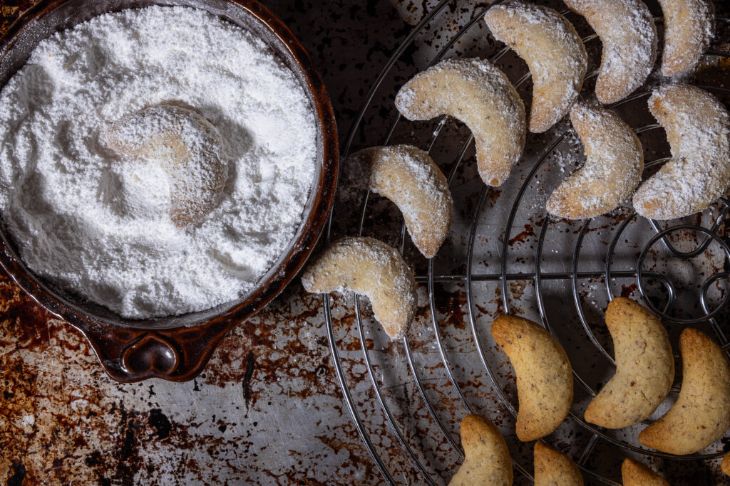 6. Die veganen Vanillekipferl ein paar Minuten abkühlen lassen und dann in dem Puderzucker-Vanillezucker-Gemisch wenden.