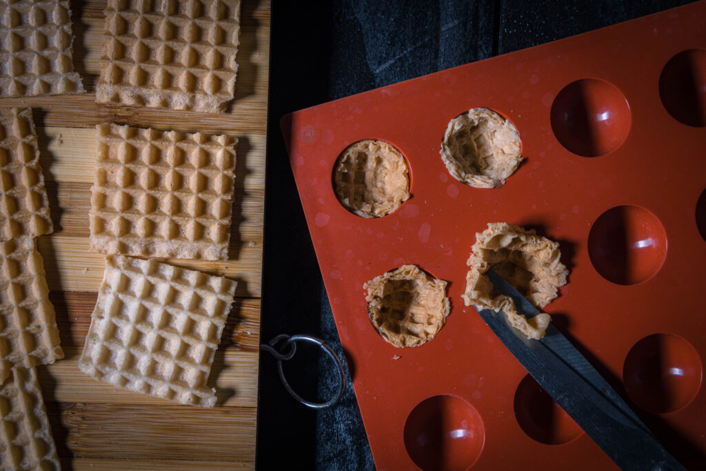 3. Sobald die Waffeln weich sind, lege ich die Formen damit aus. Die überstehenden Ecken kann man dabei am einfachsten mit einer Schere abschneiden.