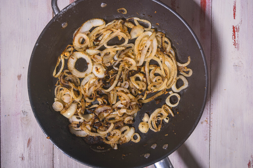 7. Die Zwiebeln im Bratfett der veganen Steaks etwa 15 Minuten schmoren.