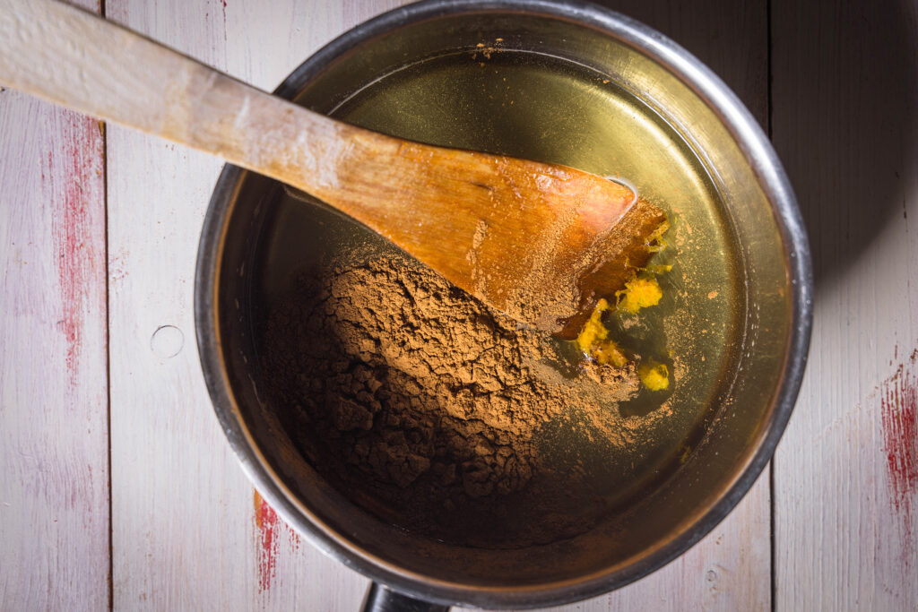 2. Zuerst das Wasser mit veganem Honig und Zucker aufkochen. Dann das Lebkuchengewürz, Orangenabrieb sowie eine Prise Salz einrühren.