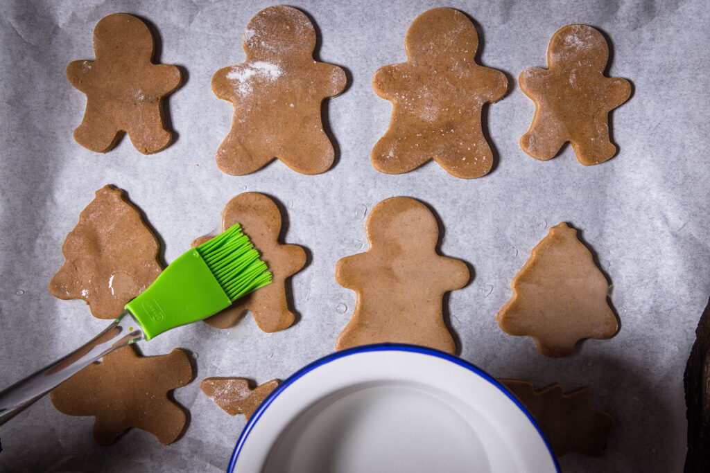 7. Die Lebkuchenfiguren mit Wasser einpinseln und 15 Minuten ruhen lassen. Dann kommen sie in den Ofen.