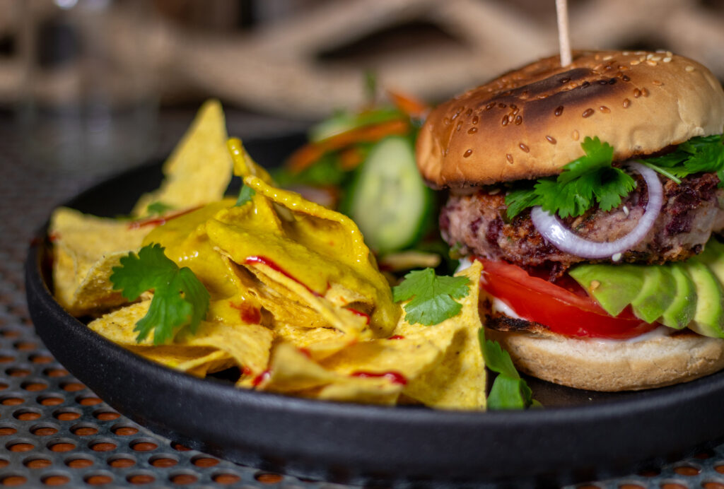 Tortilla Chips with vegan cheese sauce and a salad as side dishes for a bean burger