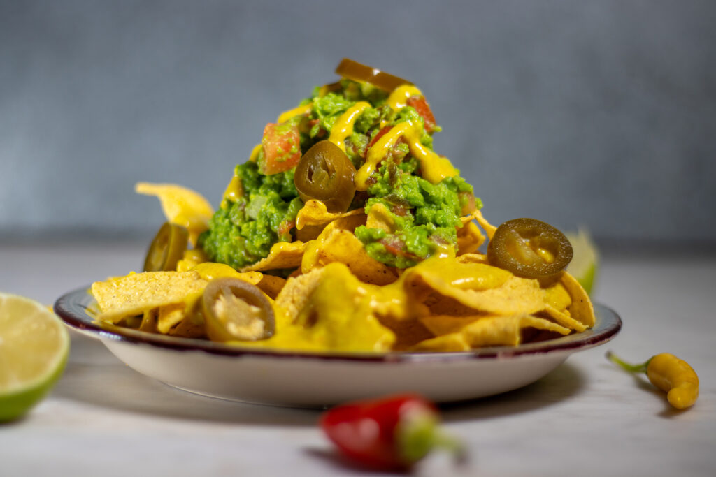 Loaded Nachos with pea guacamole and vegan cheese dip.