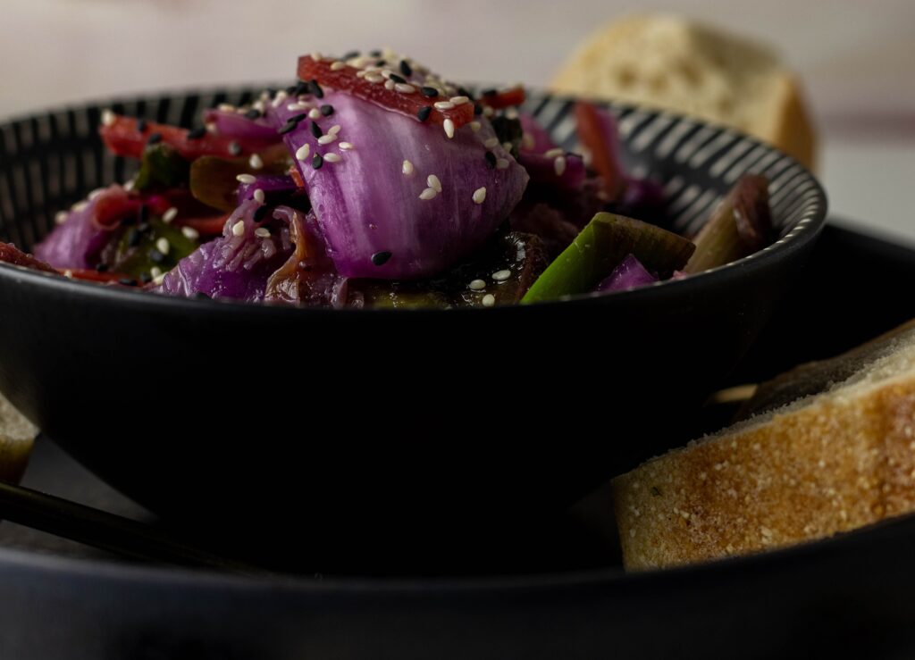 Vegan kimchi in a bowl on a plate with bread.