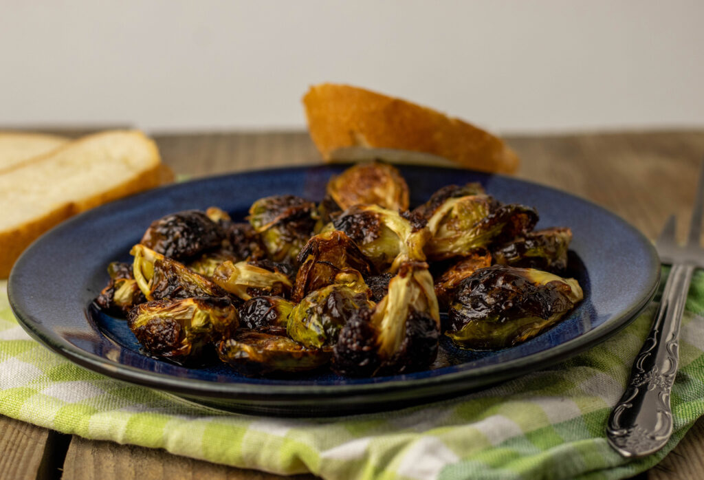 Crispy roasted Brussels sprouts on a plate on a wooden table