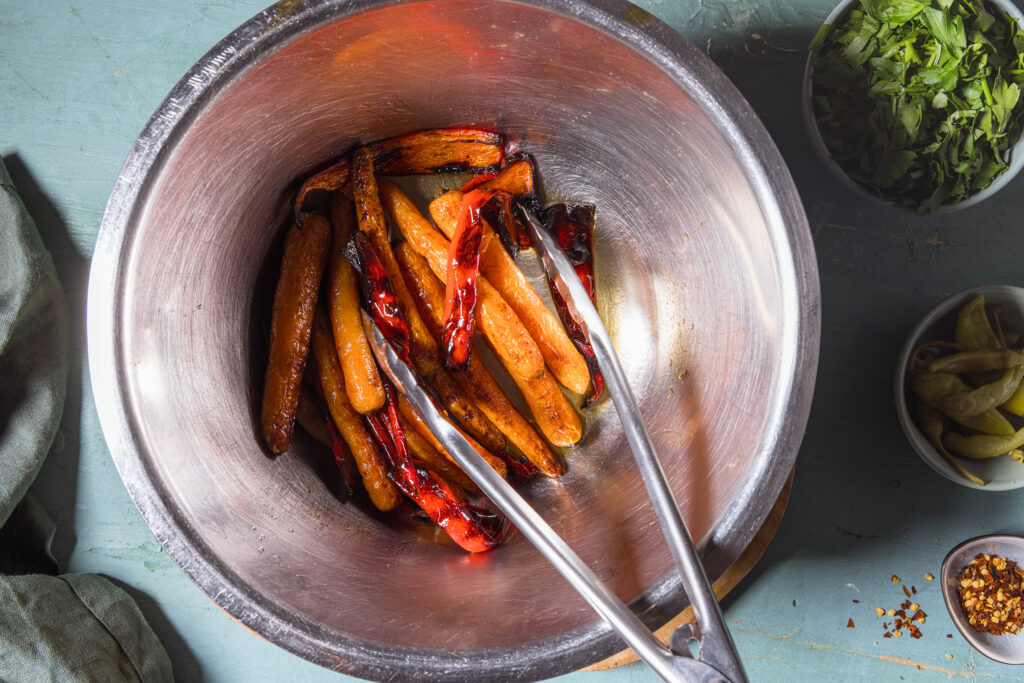 Das heiße, geröstete Gemüse wird in Holundersirup und weißem Balsamico glasiert.