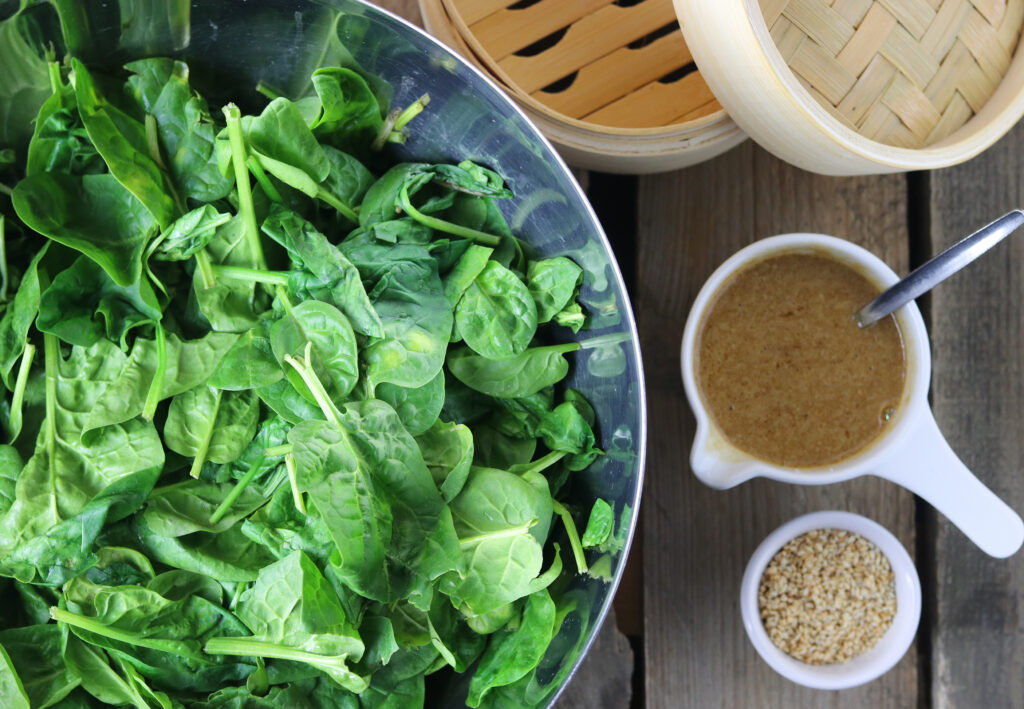 A bamboo steamer and ingredients for a Japanese spinach and sesame salad.