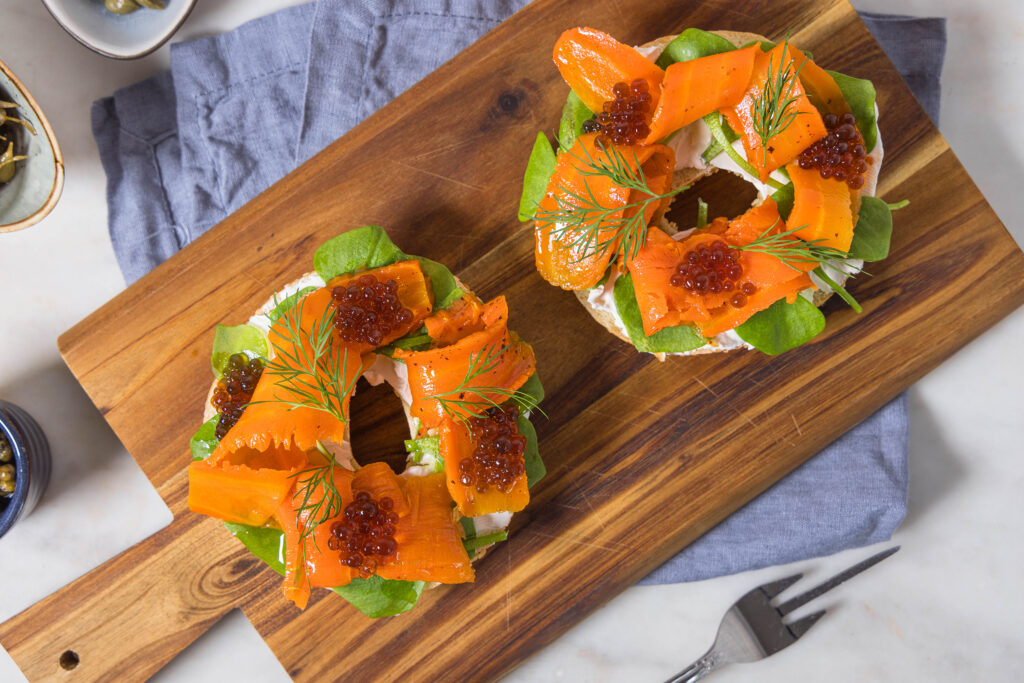 Veganer Lachs aus Karotten mit veganem Kaviar und veganem Firschkäse auf einem Bagel.