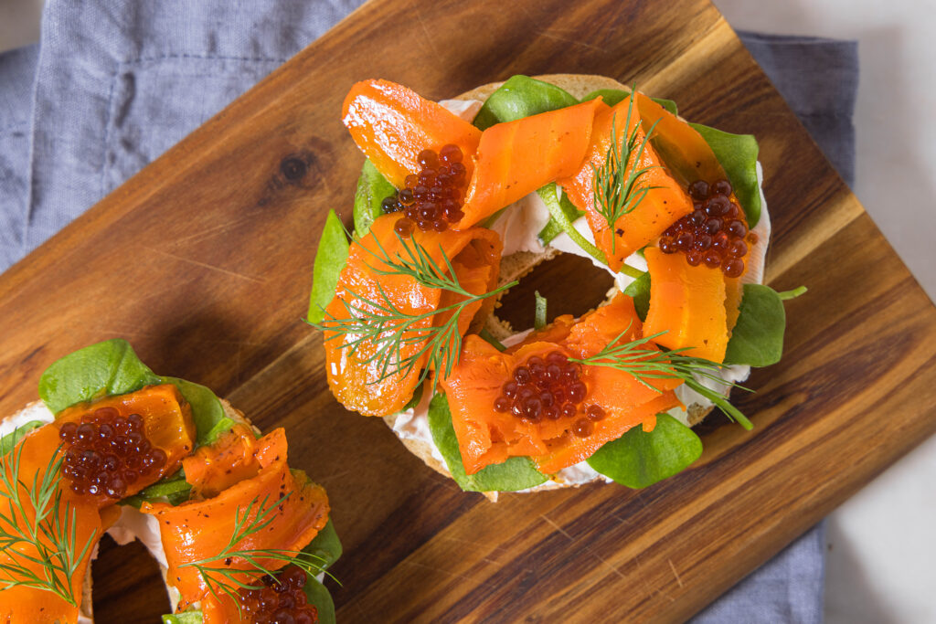 Veganer Lachs aus Karotten mit veganem Kaviar und veganem Firschkäse auf einem Bagel.