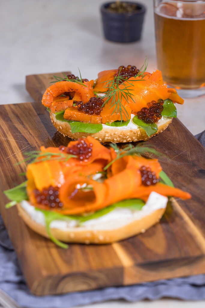 Karottenlachs – der beste vegane Lachs – im Salzmantel gegart. Hier auf einem Bagel mit veganem Frischkäse, veganem Kaviar und Dill.