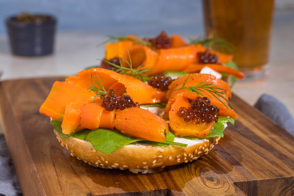 Karottenlachs – der beste vegane Lachs – im Salzmantel gegart. Hier auf einem Bagel mit veganem Frischkäse, veganem Kaviar und Dill.