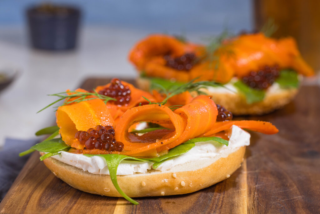 Karottenlachs – der beste vegane Lachs – im Salzmantel gegart. Hier auf einem Bagel mit veganem Frischkäse, veganem Kaviar und Dill.