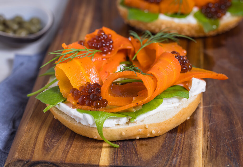 Karottenlachs – der beste vegane Lachs – im Salzmantel gegart. Hier auf einem Bagel mit veganem Frischkäse, veganem Kaviar und Dill.