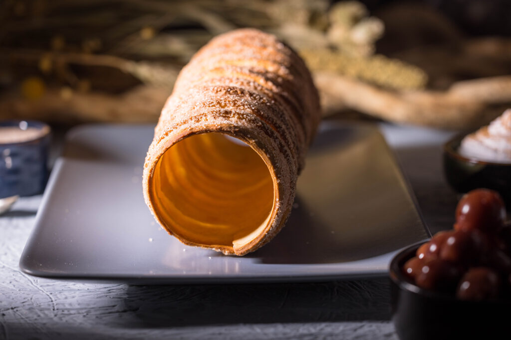 Baumstriezel, auch bekannt als Kürtőskalács, auf einem Teller.