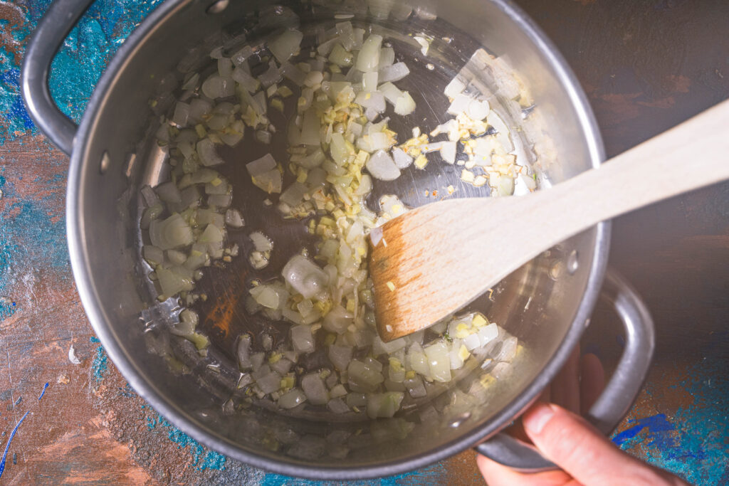 Zwiebel, Knoblauch und Ingwer braten in einem Topf.