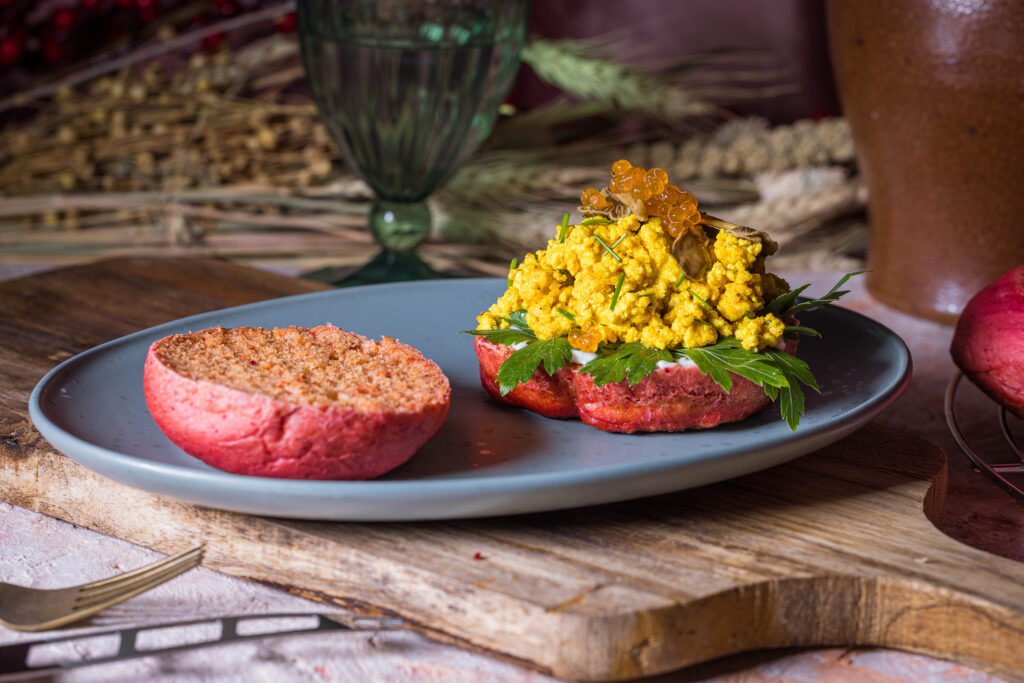 Rosa Rote Beete Pfannenbrötchen, belegt mit Scrambeld Tofu, veganem Kaviar und eingelegten Pilzen.