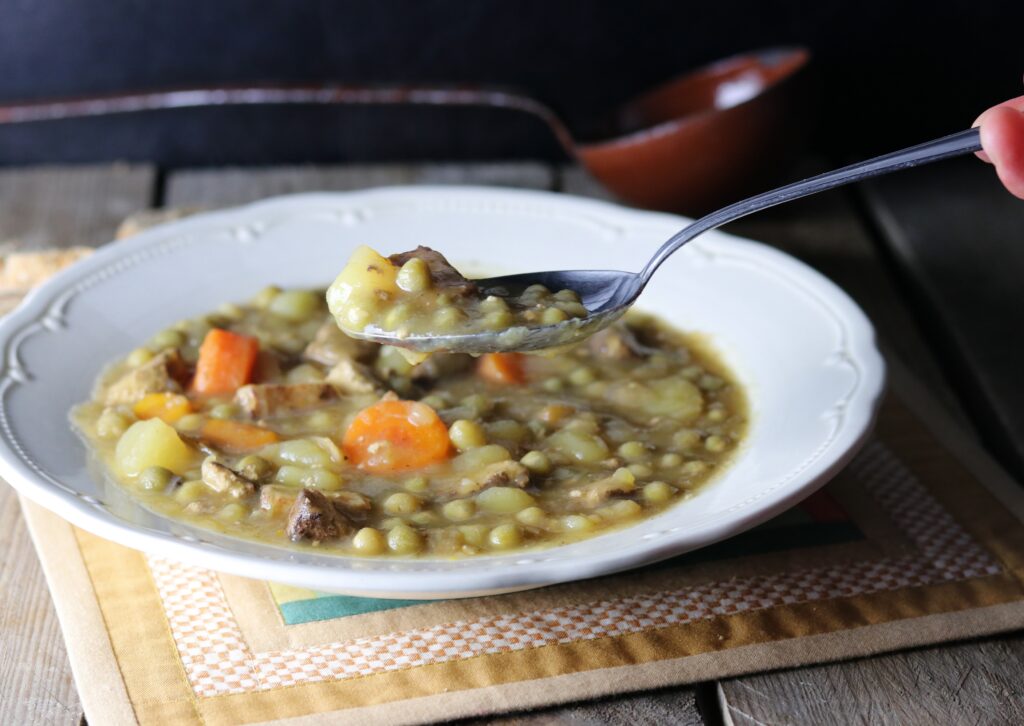 Traditional pea soup in a bowl and on a spoon.