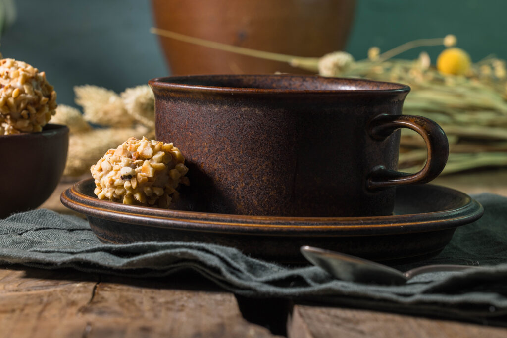 A cup of coffee, with a vegan Giotto on the saucer.